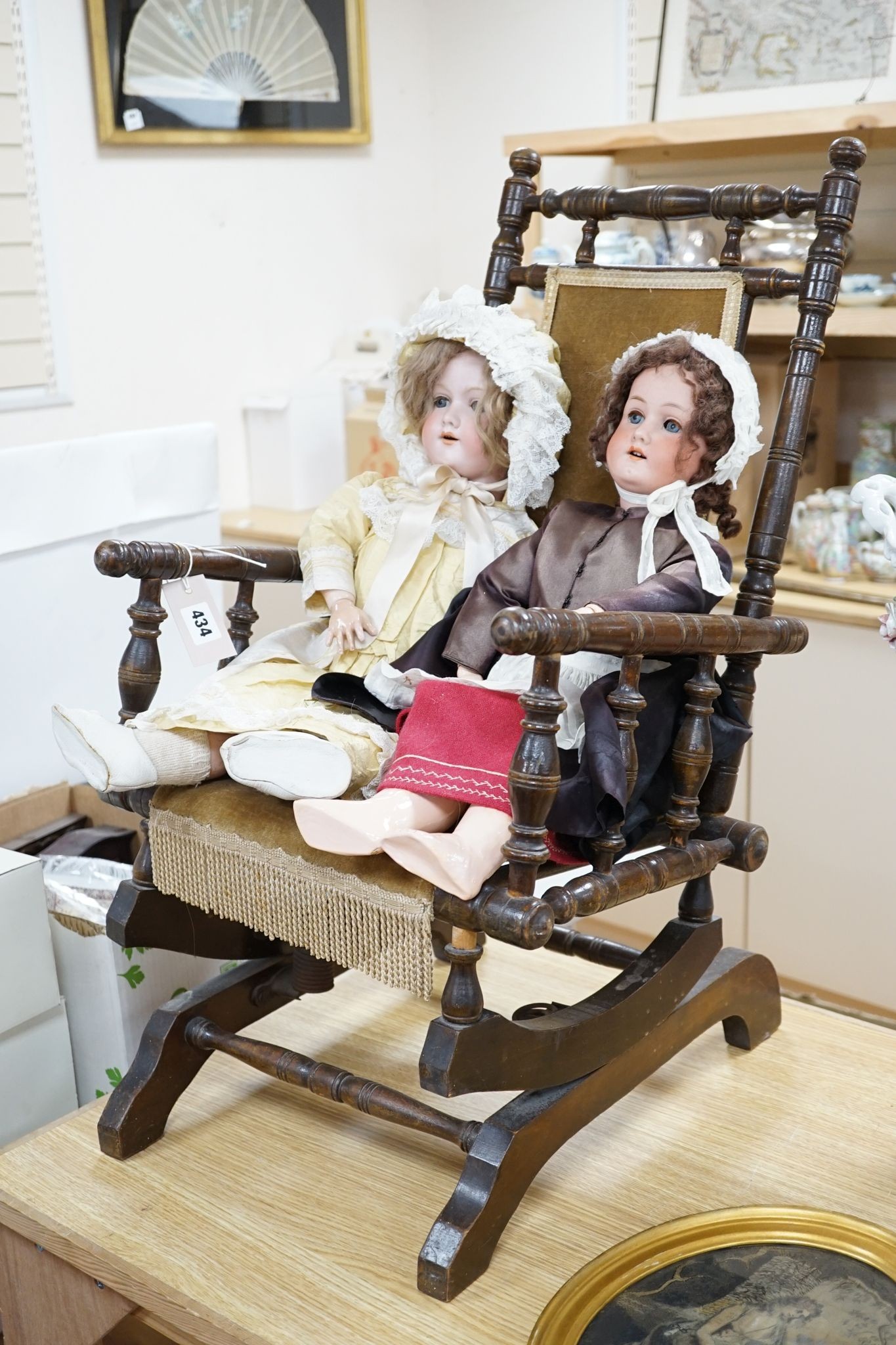 A Heubach, Koppelsdorf 250 bisque doll and an Armand Marseille 390 bisque doll, seated in turned beech rocking armchair, 73cm